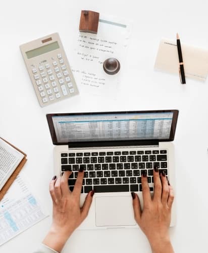 Collect your documents: job applicant preparing paperwork with laptop, calculator, and notebook on white desk